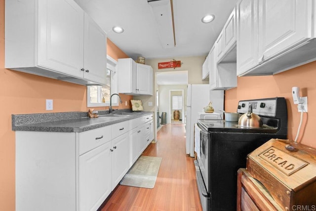 kitchen featuring white cabinetry, sink, stainless steel electric range, and light wood-type flooring