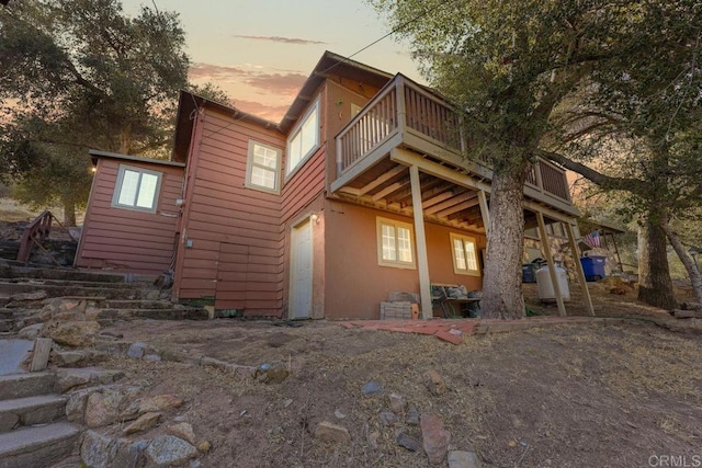 back house at dusk with a deck