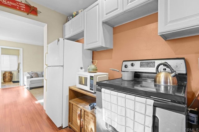 kitchen with light wood-type flooring, white cabinets, and white appliances