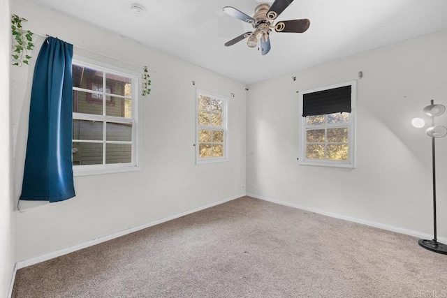 carpeted spare room featuring ceiling fan