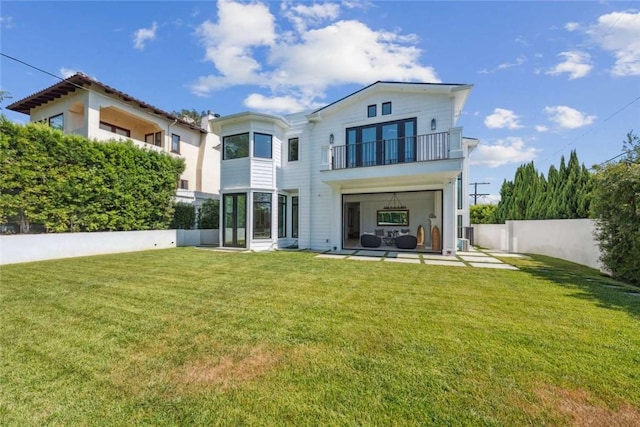 back of property featuring a balcony, a yard, and a patio area