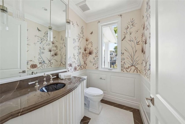 bathroom with ornamental molding, vanity, and toilet