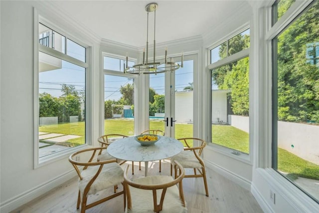 sunroom / solarium featuring a notable chandelier