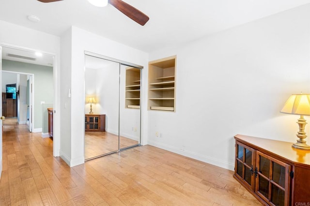 bedroom with ceiling fan, light hardwood / wood-style floors, and a closet