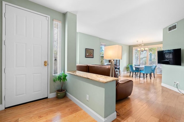 entrance foyer featuring light hardwood / wood-style flooring and a notable chandelier