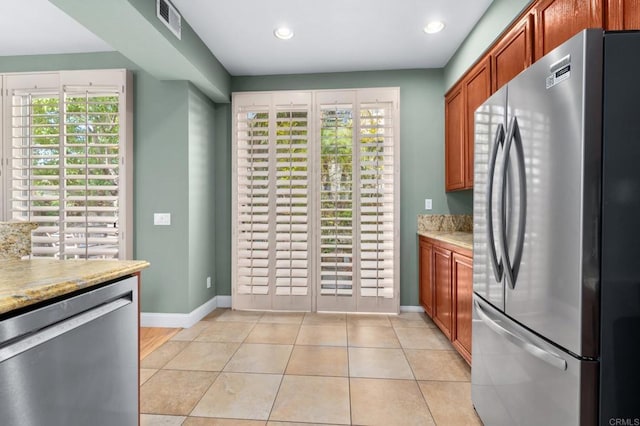 kitchen featuring light stone counters, appliances with stainless steel finishes, and light tile patterned flooring