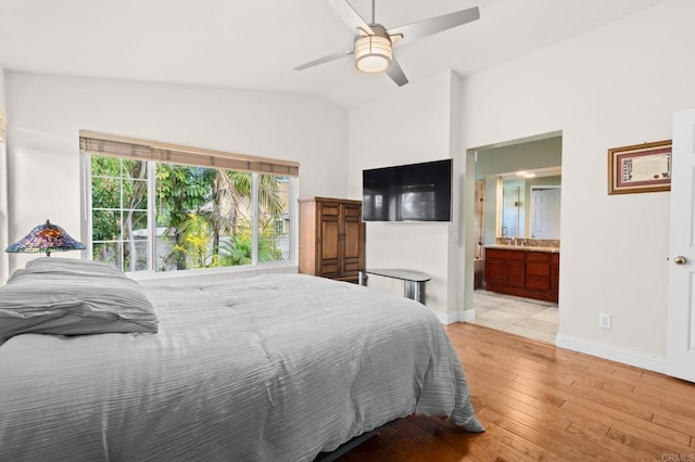 bedroom with ensuite bathroom, lofted ceiling, sink, ceiling fan, and light hardwood / wood-style flooring