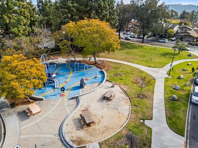 view of swimming pool with a yard and a playground