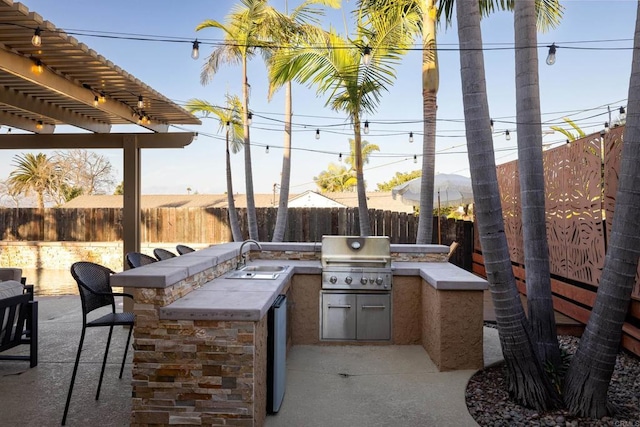 view of patio featuring exterior kitchen, a grill, and a wet bar