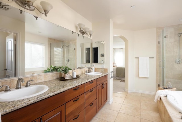 bathroom featuring independent shower and bath, vanity, and tile patterned floors