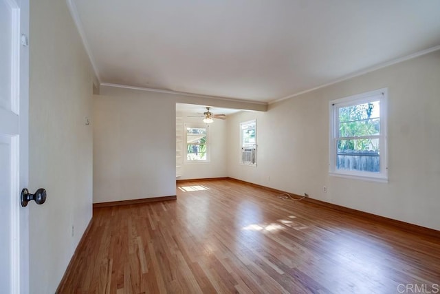 spare room featuring cooling unit, crown molding, light hardwood / wood-style flooring, and ceiling fan