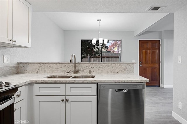 kitchen featuring dishwasher, sink, white cabinets, hanging light fixtures, and light wood-type flooring