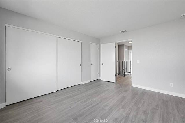 unfurnished bedroom with a closet and light hardwood / wood-style flooring