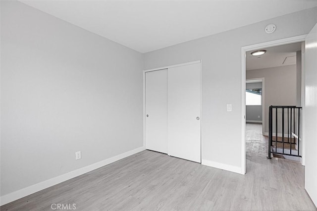 unfurnished bedroom featuring a closet and light hardwood / wood-style flooring