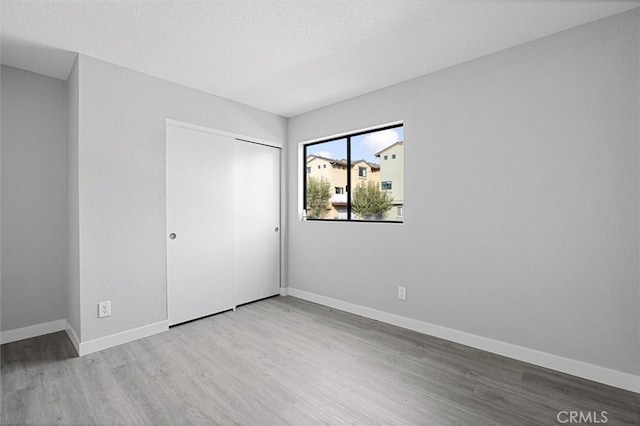 unfurnished bedroom with a closet and light hardwood / wood-style flooring