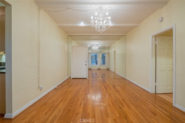 hallway with a notable chandelier and light hardwood / wood-style flooring