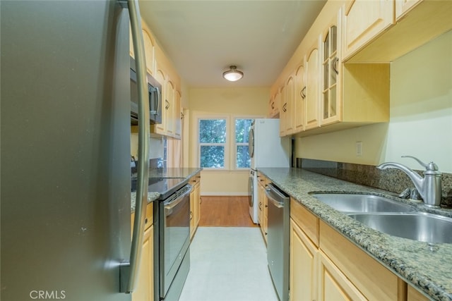 kitchen featuring sink, stainless steel appliances, stone counters, and light brown cabinets