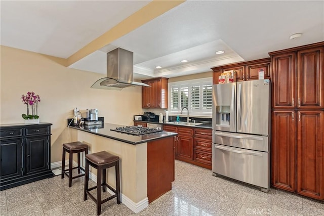 kitchen featuring appliances with stainless steel finishes, a breakfast bar, sink, island exhaust hood, and kitchen peninsula