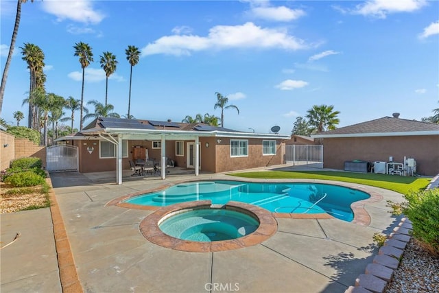 view of swimming pool featuring an in ground hot tub, a yard, and a patio