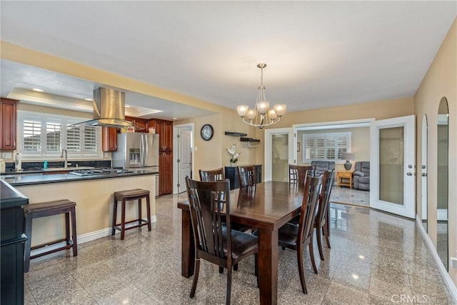 dining room featuring sink and a chandelier