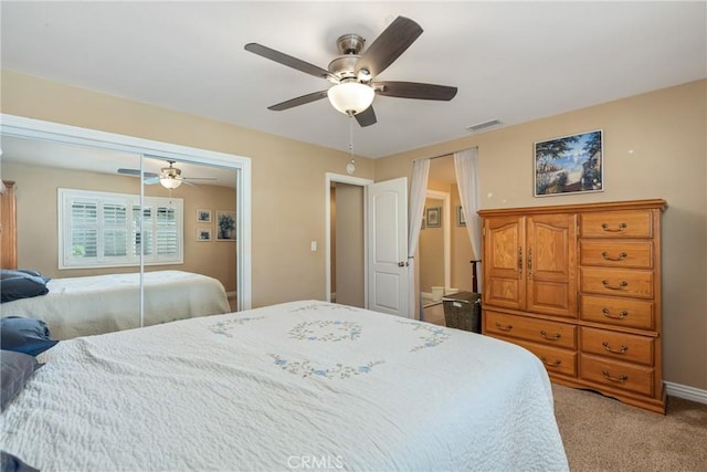 bedroom featuring ceiling fan, a closet, and light carpet