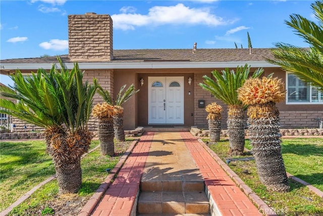 doorway to property featuring a lawn