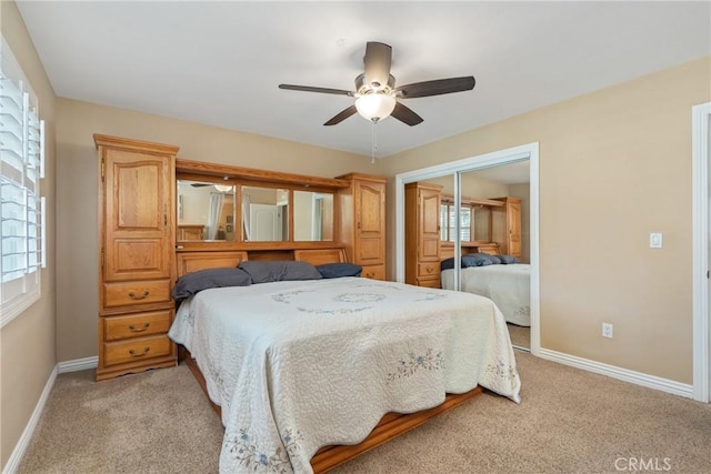 carpeted bedroom with multiple windows, a closet, and ceiling fan