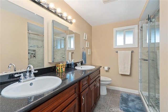 bathroom featuring vanity, a shower with door, and toilet