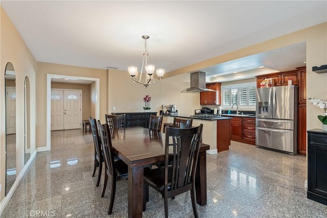 dining room featuring an inviting chandelier, sink, and a raised ceiling