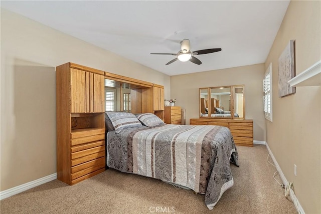 carpeted bedroom featuring multiple windows and ceiling fan