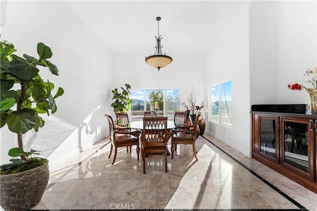 dining room with a fireplace and a high ceiling