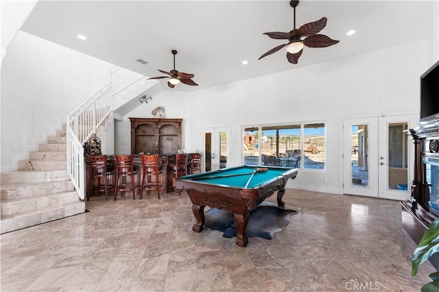 rec room featuring french doors, pool table, bar area, and a towering ceiling