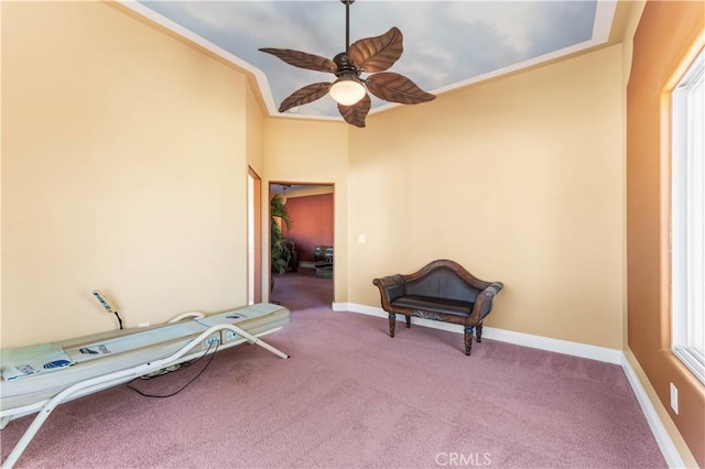 living area with crown molding, carpet flooring, and ceiling fan