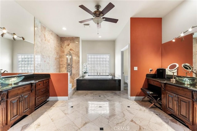 bathroom featuring vanity, ceiling fan, a bathtub, and toilet