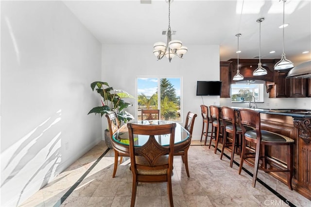 dining room featuring sink and a chandelier