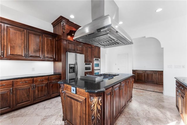 kitchen with dark brown cabinetry, island range hood, appliances with stainless steel finishes, a kitchen island, and dark stone counters