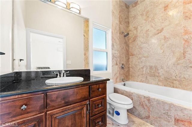 full bathroom featuring vanity, tiled shower / bath combo, and toilet