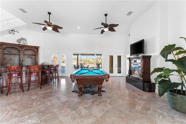 game room with billiards, ceiling fan, a towering ceiling, french doors, and indoor bar