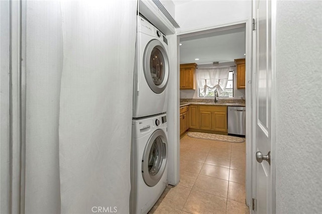 washroom with stacked washer and clothes dryer, sink, and light tile patterned floors