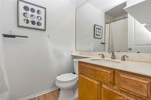 bathroom with vanity, wood-type flooring, and toilet