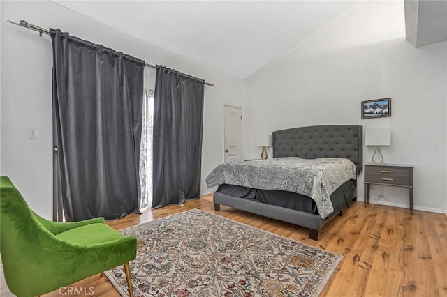 bedroom with lofted ceiling and light hardwood / wood-style floors