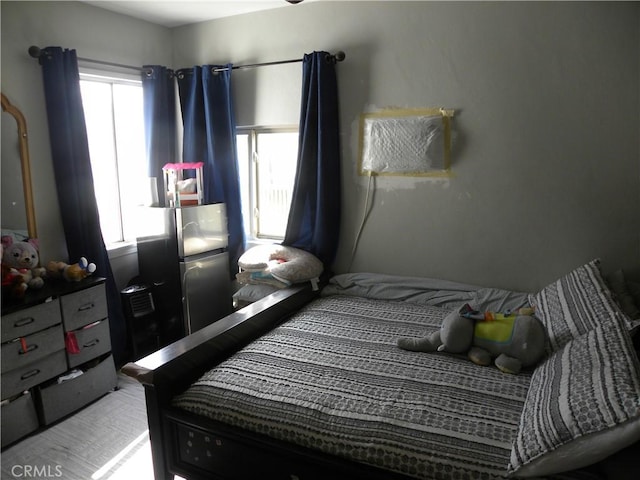 bedroom featuring stainless steel fridge