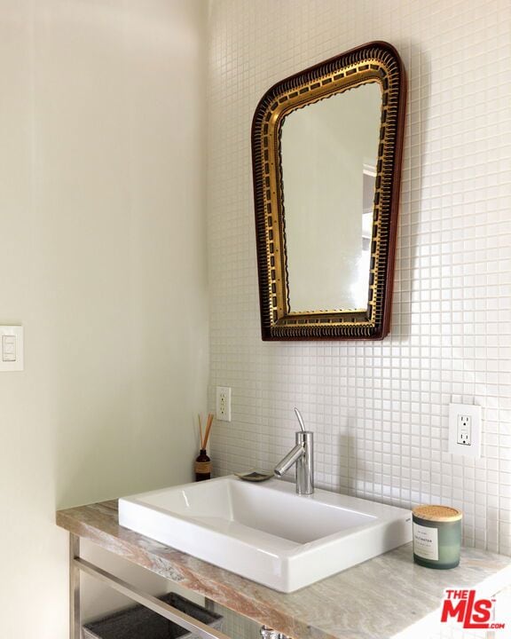 bathroom with sink, tile walls, and decorative backsplash