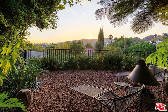 yard at dusk featuring a mountain view