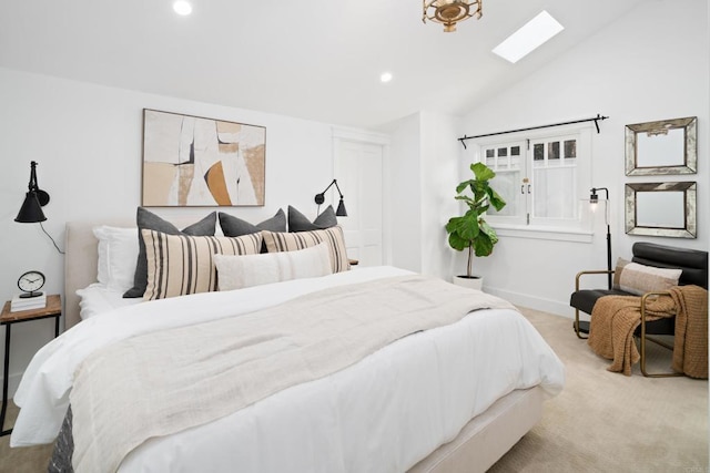 bedroom with vaulted ceiling with skylight and light carpet