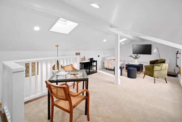 interior space with light colored carpet and vaulted ceiling with skylight