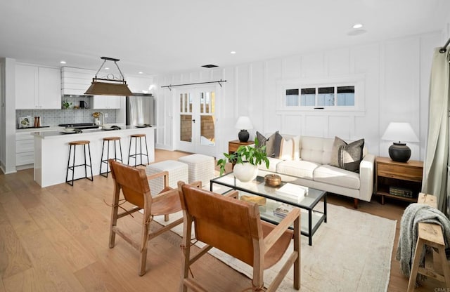 living room featuring light wood-type flooring and french doors