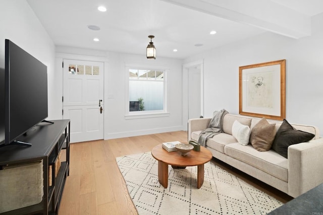 living room with beam ceiling and light wood-type flooring