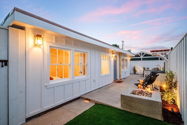 patio terrace at dusk featuring an outdoor fire pit