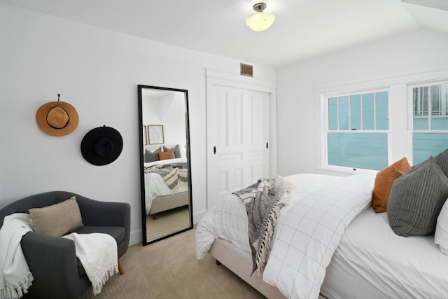 bedroom with light carpet and a closet